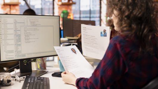 Startup HR worker identifying right candidates for job opening, reviewing resumes to determine qualifications. Woman doing screening process, selecting skilled people for software development position